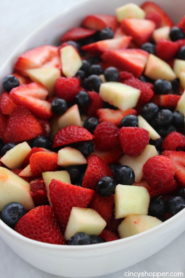 Red White and Blue Fruit Salad- Perfect for July 4th! Red strawberries, red raspberries, and white apples all mixed with a yummy lime dressing.