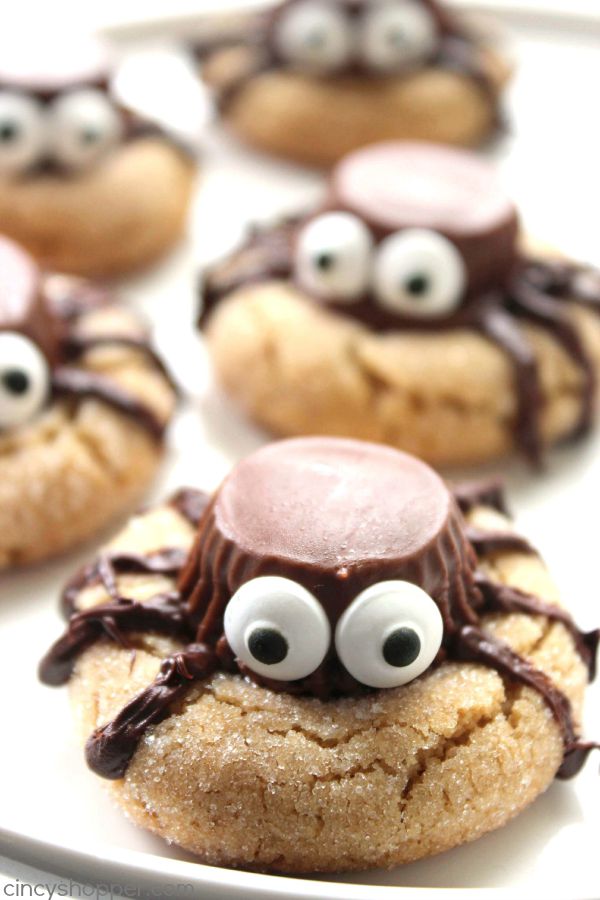Halloween Spider Cookies - perfect party treat. We start with a simple peanut butter blossom cookie, top it with a Reese's Miniature, add on some eyes and some legs.