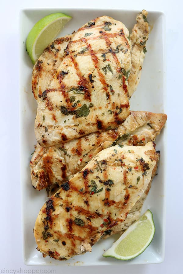 The marinade for this Cilantro Lime Grilled Chicken is so simple to make! We marinade our chicken breasts in cilantro, lime, and a few other ingredients. Then we toss them on the grill to cook them up. Perfect chicken recipe for summer grilling.
