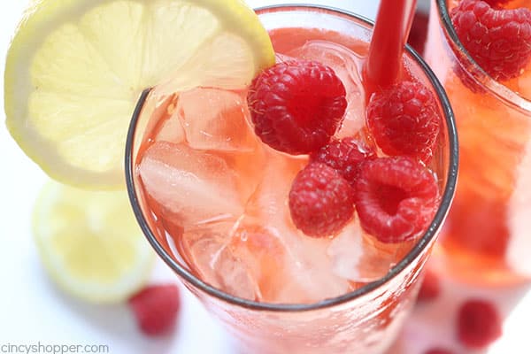 Raspberry Iced Tea - super refreshing cold beverage for hot summer days. We make it with fresh raspberries, squeezed lemon, and just a bit of sugar. Feel free to add in more sugar if you like your tea super sweet. #IcedTea #Raspberries #SummerDrink