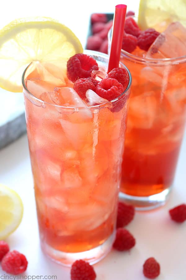 Raspberry Iced Tea - super refreshing cold beverage for hot summer days. We make it with fresh raspberries, squeezed lemon, and just a bit of sugar. Feel free to add in more sugar if you like your tea super sweet. #IcedTea #Raspberries #SummerDrink
