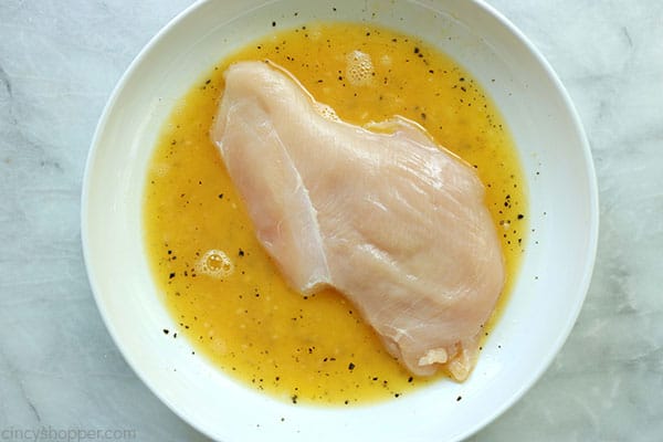 Chicken breast in egg wash.