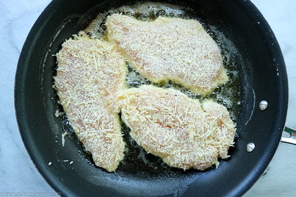 Cheese coated chicken in a pan