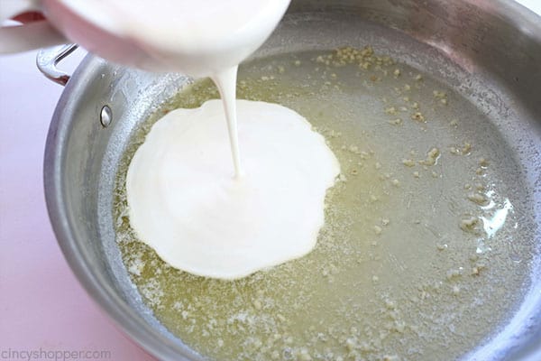 Adding heavy cream to butter and garlic