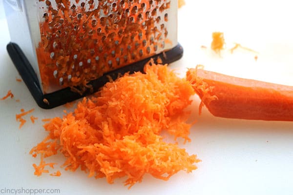 Grating fresh carrots for the best carrot cake