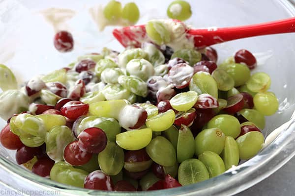 Tossing grape salad ingredients in a bowl.