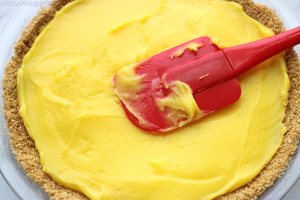 Adding lemon pie filling to graham cracker crust.