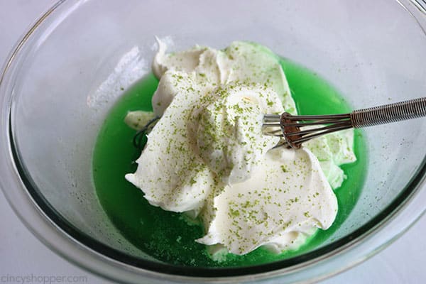 Adding whipping cream and lime zest to lime Jello for lime cheesecake.