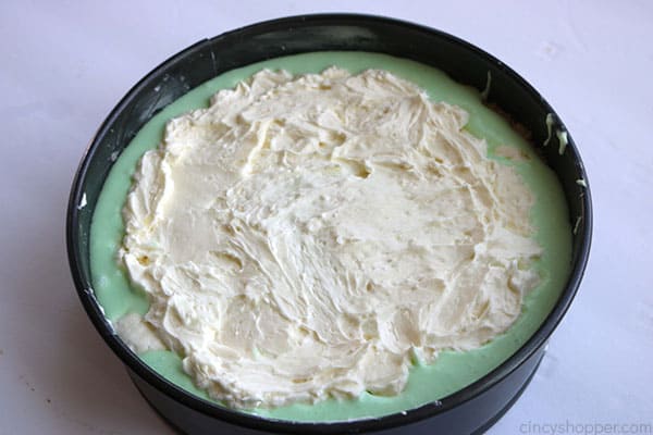 Adding cream cheese mixture to lime cheesecake.