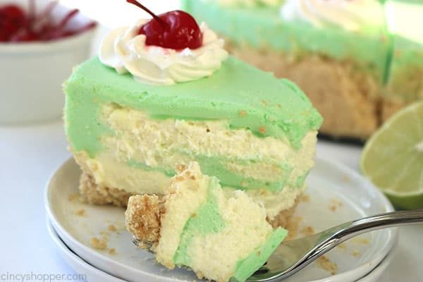 Slice of no bake cheesecake lime flavored on a plate with fork.