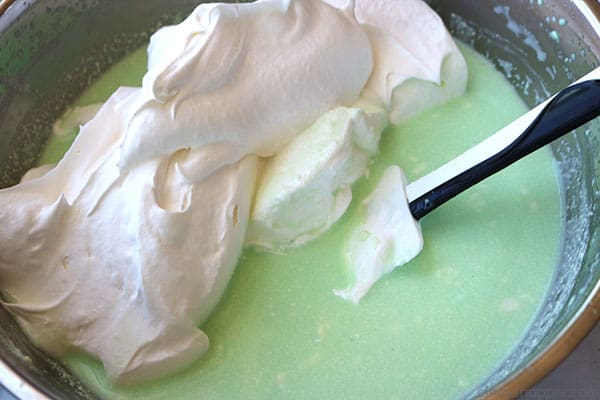 Adding whipped topping to Retro 7UP Jello salad.