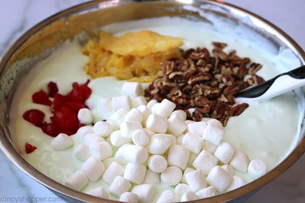 Adding ingredients to bowl with Creamy Lime Jello Salad.