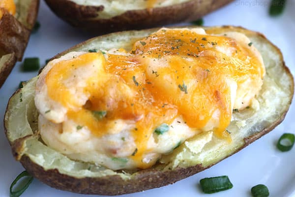 Easy Twice Baked Potato on a white plate with green onions.