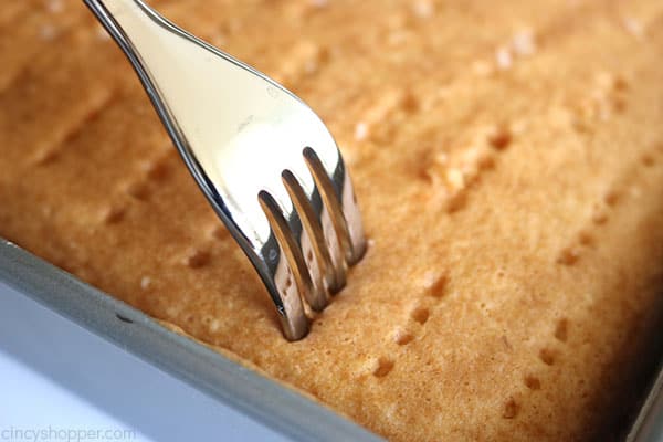 Poking holes in cake for American Flag Poke Cake.