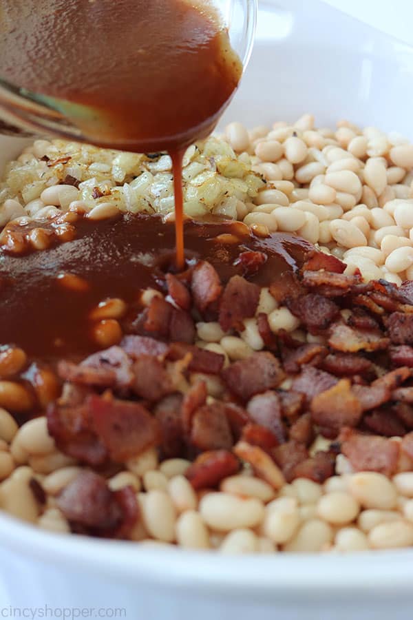 Adding sauce to baked beans.