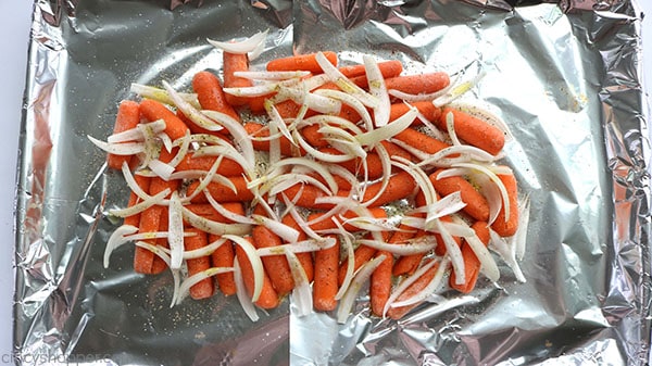 Onions and carrots on a sheet pan with foil.
