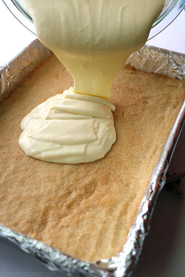 Pouring cheesecake mixture on shortbread crust.