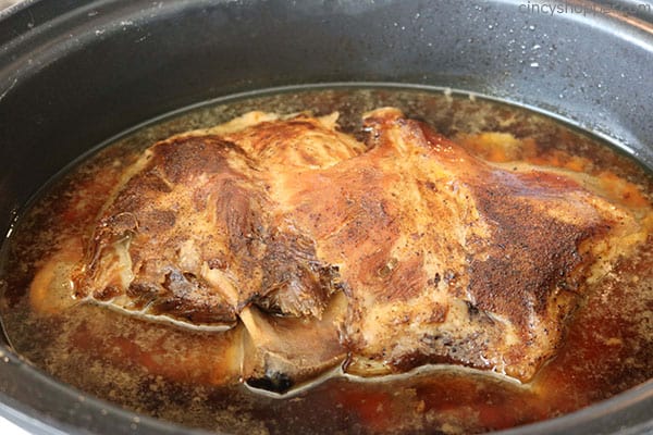 Cooked pork butt inside of slow cooker.