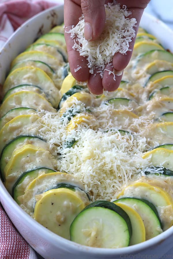 Topping Parmesan Zucchini Casserole with cheese.