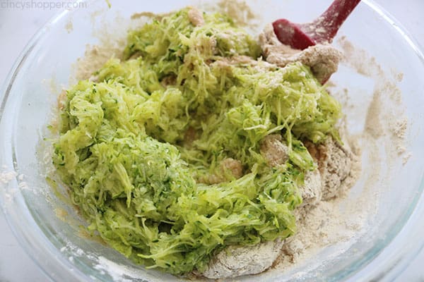 Adding shredded zucchini to mixture.