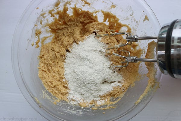 Adding flour mixture to pumpkin cookie dough.