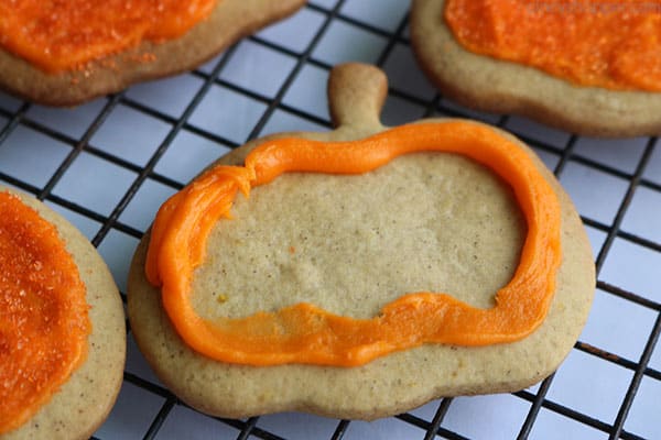 Frosting pumpkin shaped cookie.