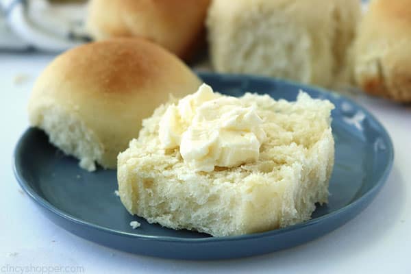 Easy dinner roll swith butter on a blue plate.