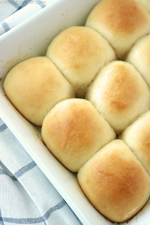 Soft homemade dinner rolls in a white dish.