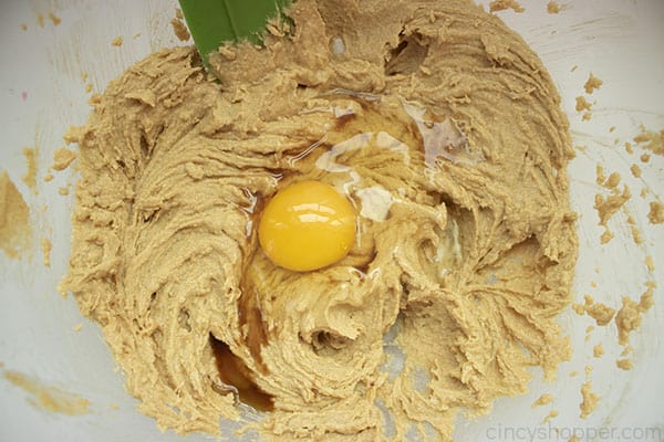 Adding egg to peanut butter cookie dough