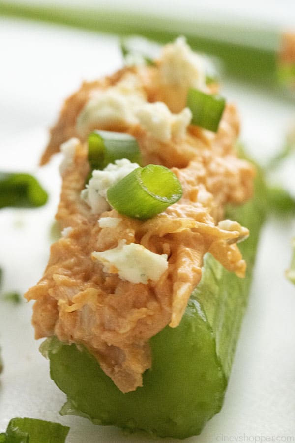 close up of cut celery stick with spicy chicken