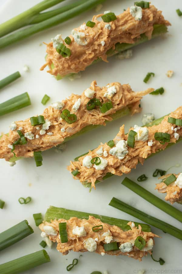 slices of celery with Buffalo chicken topped with blue cheese and green onions