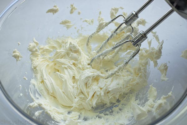 Beating cream cheese in a mixing bowl