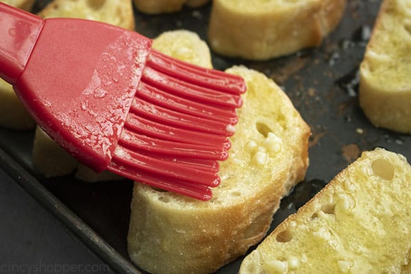 A silicone brush is used to apply the sauce to the toast