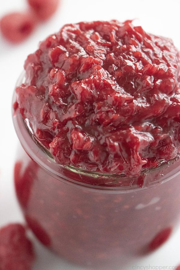 close up of homemade red raspberry fruit filling in glass jar