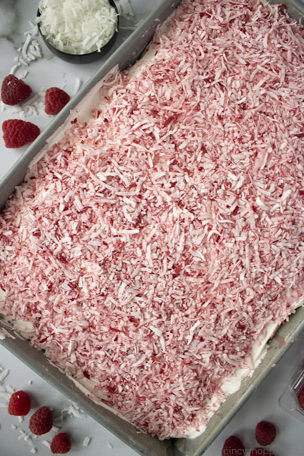 Poke Cake with coconut in a baking pan.