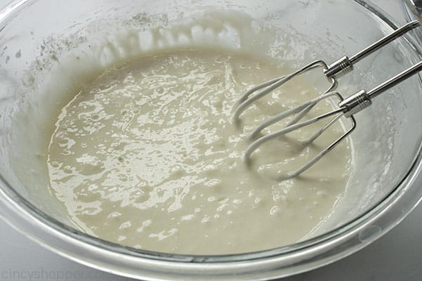 Bowl with white cake mix with mixer.