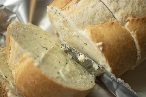 spreading garlic butter onto bread slices