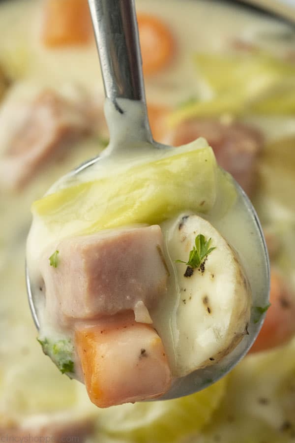 Spoon with creamy cabbage, ham, potatoes, and carrots