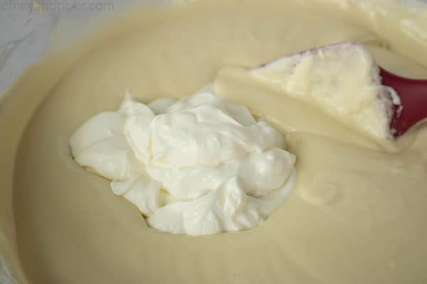 stirring sour cream into cheesecake filling