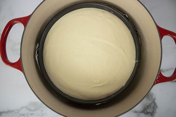 new york style cheesecake in a water bath inside a dutch oven