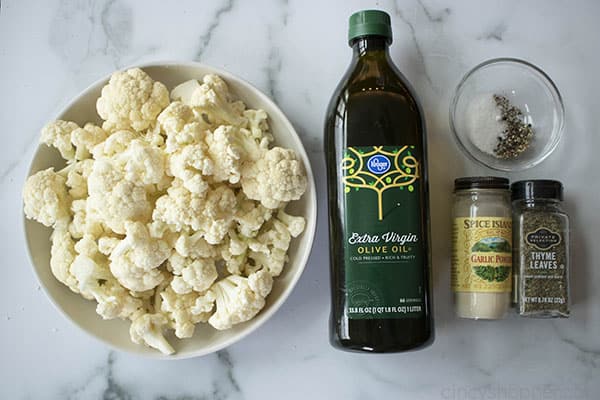 ingredients for Roasted Cauliflower, including cauliflower, olive oil, garlic powder, thyme, salt and pepper