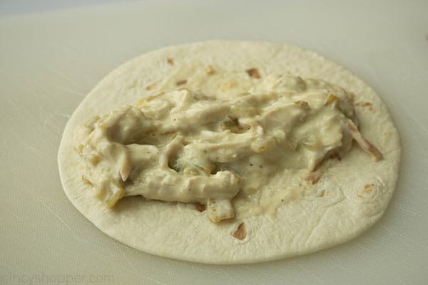 white chicken enchilada filling on a flour tortilla