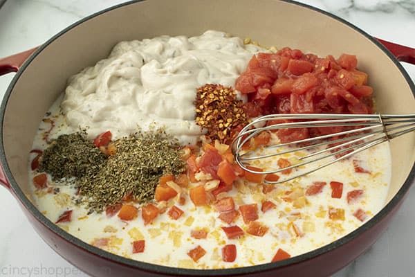 preparing a chicken spaghetti recipe by combining ingredients in a skillet