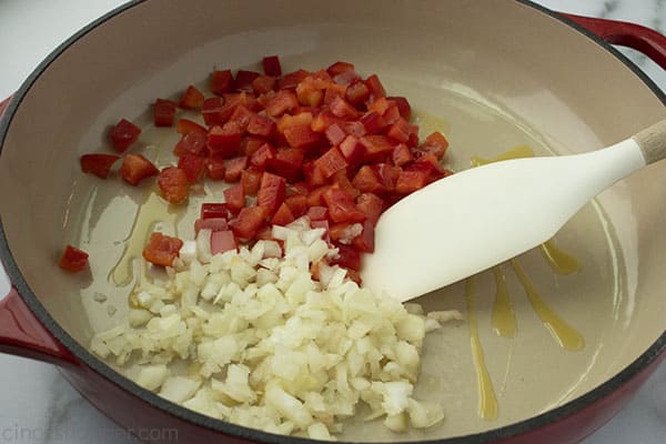 cooking diced onion and red bell pepper in a skillet