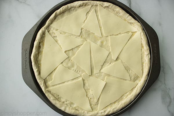 triangles of white American cheese slices on top of pizza crust