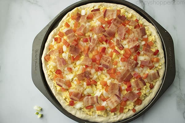 pieces of cooked bacon on top of a breakfast pizza