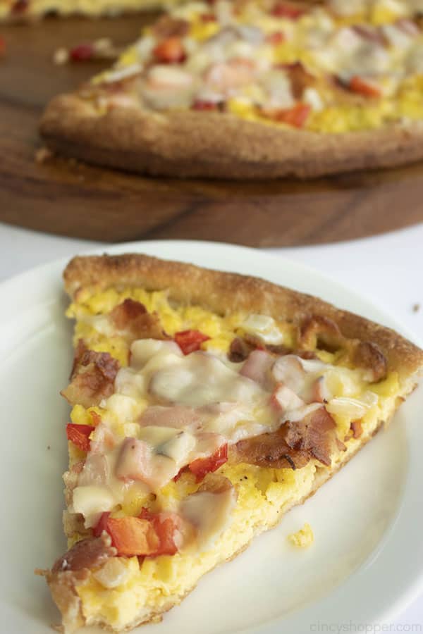 slice of pizza with bacon, eggs and cheese on top