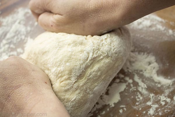 Kneading homemade pizza dough on a floured surface