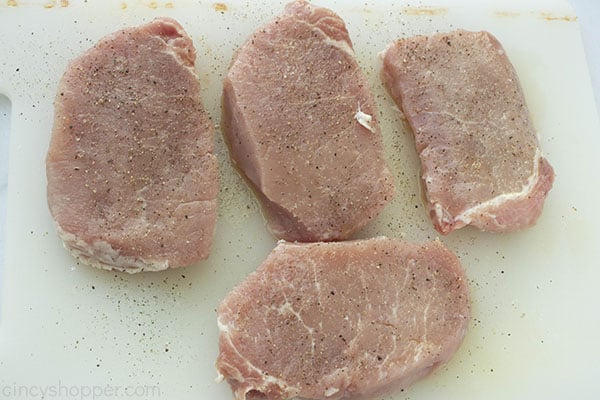 Boneless Pork Chops with salt and pepper on a white board