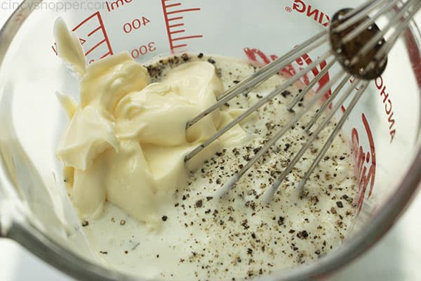 Whisking mayo and ranch dressing in a measuring cup.